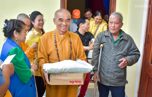 Thượng tọa Thích Tuệ Hải hỗ trợ một cụ ông nhận quà