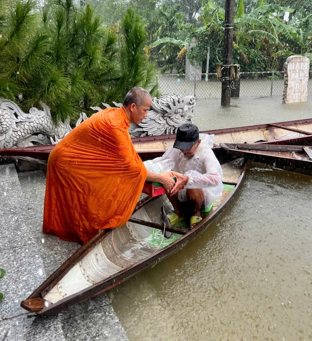 Đại đức Thích Minh Phú trao quà đến người dân thôn Tứ Chánh - nơi đang bị cô lập hoàn toàn bởi nước lũ