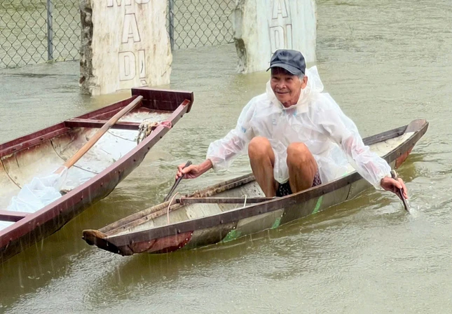 Một cụ già bơi xuồng đến nhận quà tại chùa Tứ Chánh