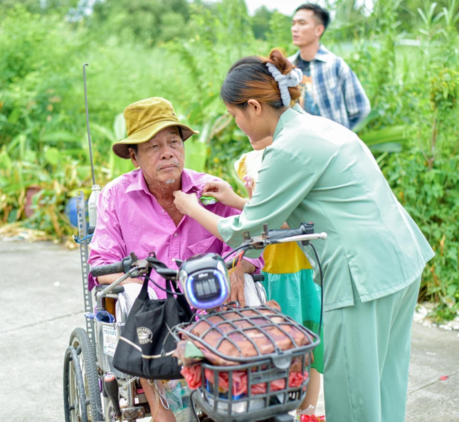 Phật tử cài hoa hồng trắng cho một người dân đến tham dự