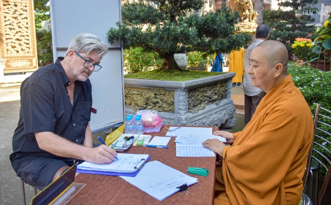 Ông Robert William Neil (Australia) sau khi được chư Tăng chia sẻ về ý nghĩa của ngày rằm tháng Bảy cũng đã ghi danh cầu nguyện cho người thân của mình