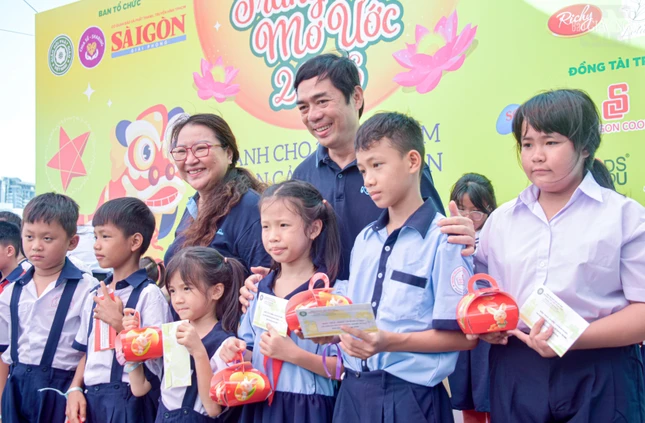 Ông Nguyễn Khắc Cường, bà Trần Gia Bảo, đồng Phó Tổng Biên tập Báo Sài Gòn Giải Phóng trao quà trung thu đến các em học sinh