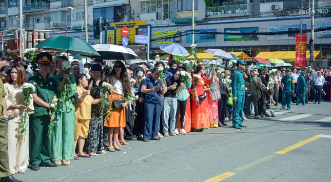 Người dân TP.HCM tay cầm nhành hoa trắng, đứng đợi dưới trời nắng nóng để tiễn đưa các anh hùng liệt sĩ