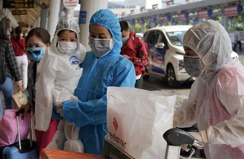 Người dân với trang phục bảo hộ đến sân bay Tân Sơn Nhất