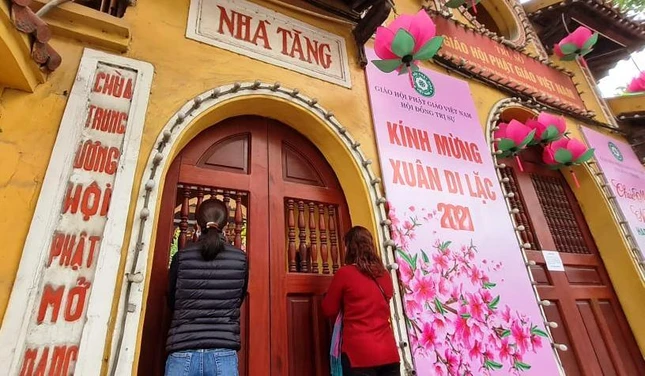 Một vài người dân đến chùa đứng ngoài tam quan bái vọng cầu nguyện