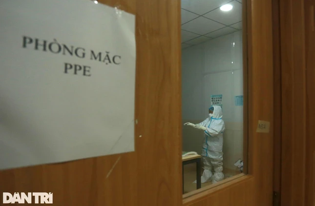 Đúng 21 giờ đêm, 15 y bác sĩ của khu vực điều trị bệnh nhân nặng và nguy kịch hoàn tất việc trang bị đồ bảo hộ ở phòng mặc PPE. Sẵn sàng vào thay ca cho đồng nghiệp.