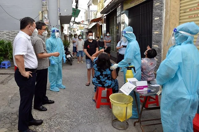 Phó Thủ tướng Vũ Đức Đam đề nghị đội lấy mẫu Trường Đại học Y Thái Bình hướng dẫn người dân ở Hẻm 83, đường Bông Sao (quận 8) tự lấy mẫu xét nghiệm nhanh - Ảnh: VGP/Đình Nam