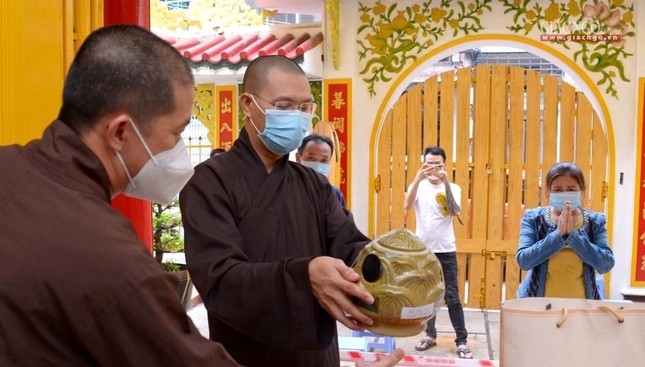 Đại đức Thích Minh Thật tiếp nhận tro cốt đồng bào đến gửi - Ảnh: Bảo Toàn