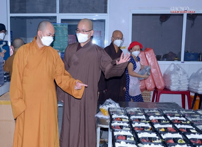 Đại đức Thích Minh Đạo hướng dẫn Thượng tọa Thích Đức Thiện thăm nơi phân phối các suất cơm theo thực đơn đủ dinh dưỡng thay đổi hàng ngày