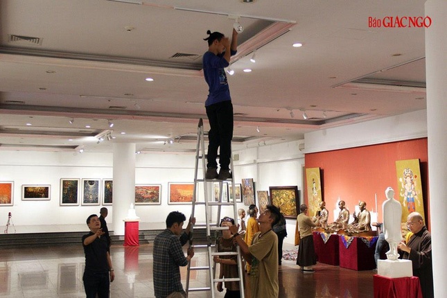 Treo tranh và cân chỉnh ánh sáng chuẩn bị cho triển lãm Sen đầu hạ chào mừng Đại hội