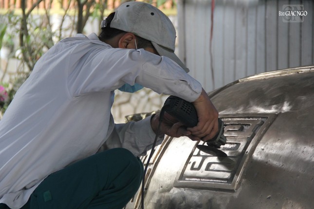 Kỹ thuật viên đang lấy nét đại tự trang trí trên thân chuông