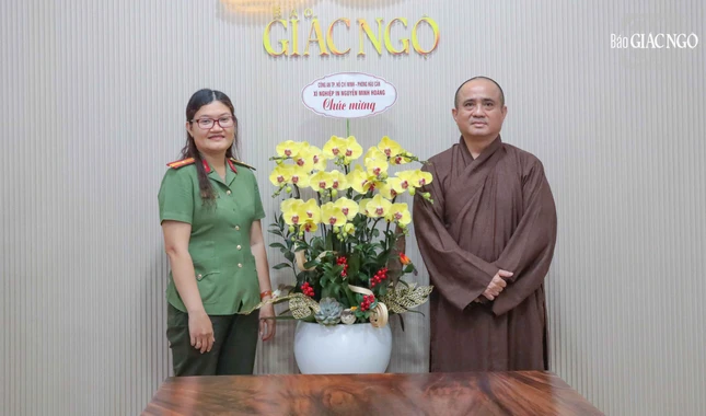 Thiếu tá Nguyễn Thị Kim Chi, Phó Giám đốc Xí nghiệp in Nguyễn Minh Hoàng tặng hoa chúc mừng Ngày Báo chí Cách mạng Việt Nam