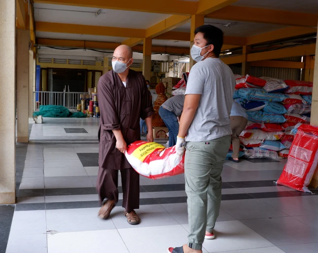 Thượng tọa Thích Thanh Phong chuyển nhu yếu phẩm lên xe trao đến người dân khu vực cách ly