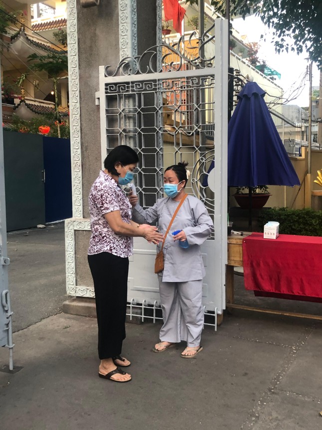 Phật tử được đo thân nhiệt và rửa tay sát khuẩn tại tịnh xá Trung Tâm