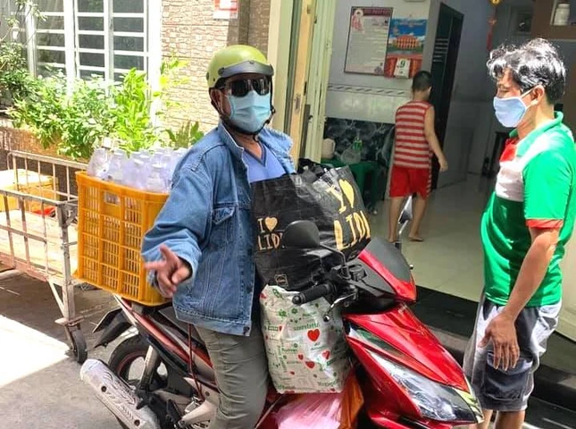 Tình nguyện viên chở các suất cơm tặng đến người nghèo, cơ nhỡ TP.HCM - Ảnh: T.N