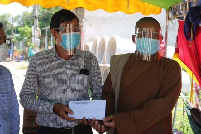 Đại đức Thích Lệ Duyên trao quà đến đại diện khu cách ly phòng Covid-19