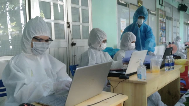 Tình nguyện viên hỗ trợ ghi danh sách người dân tiêm vắc-xin