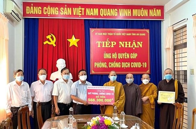 Thượng tọa Thích Thiện Thống trao bảng ủng hộ quỹ phòng chống Covid-19 - Ảnh: MTTQVN AG