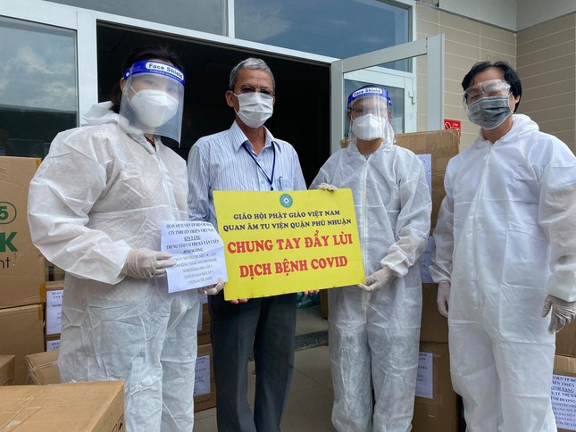 Sư cô Thích nữ Huệ Đức, Cty gỗ Tiến Triển trao quà đến đại diện Trung tâm Y tế thị xã Tân Uyên - Ảnh: QÂTV