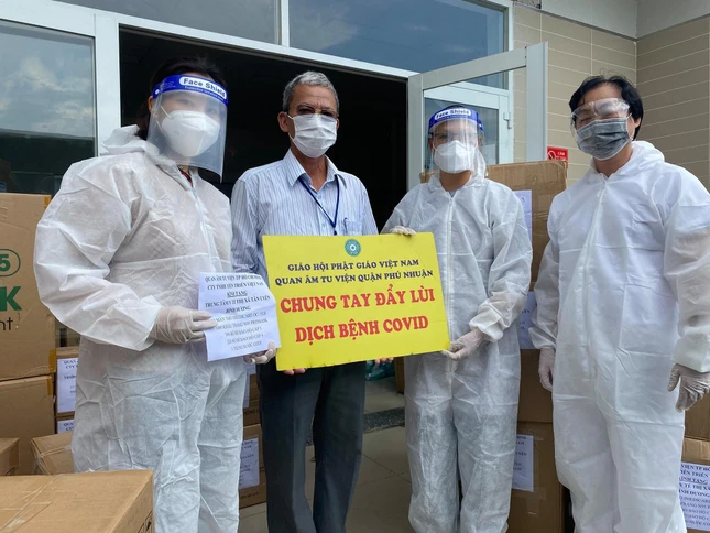 Sư cô Thích nữ Huệ Đức, Cty gỗ Tiến Triển trao quà đến đại diện Trung tâm Y tế thị xã Tân Uyên - Ảnh: QÂTV