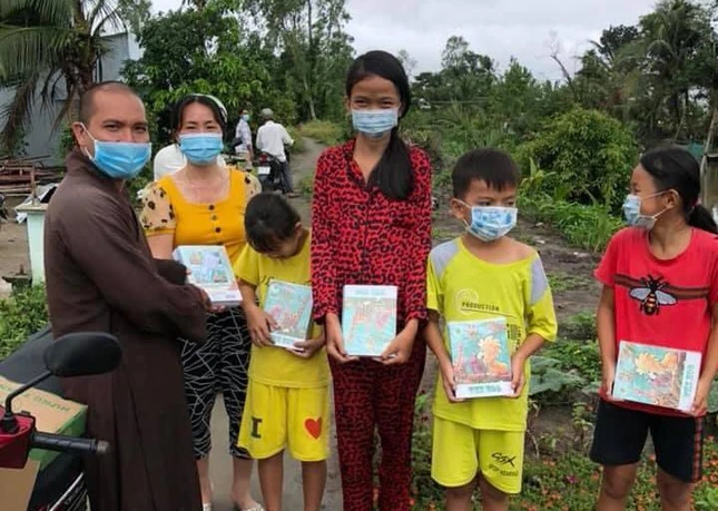 Đại đức Thích Minh Kính trao tập cho học sinh nghèo