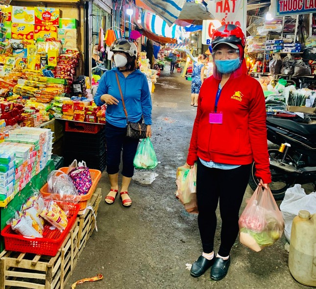 Bà Phan Thị Hoa (phải) hỗ trợ đi chợ hằng ngày phục vụ người dân bị phong tỏa