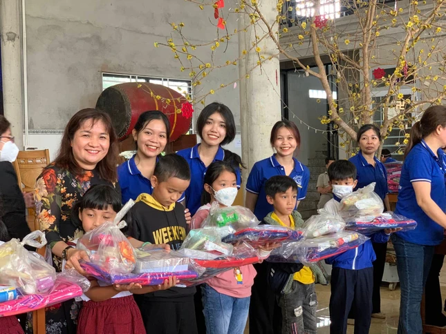 Thành viên đoàn trao quà đến các em học sinh