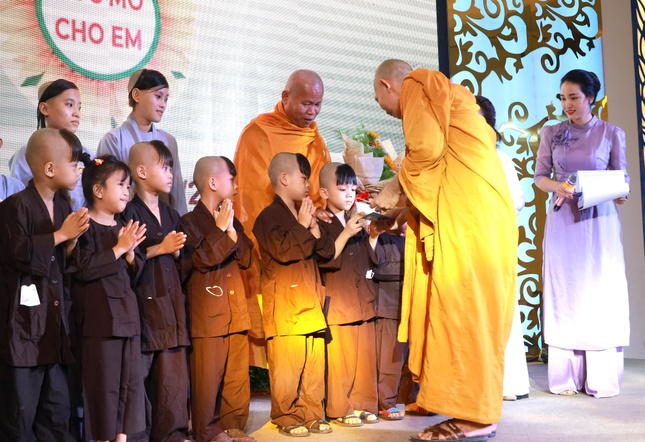 Đại đức Thích Giác Thống đang trao sổ tiết kiệm cho các bé mồ côi