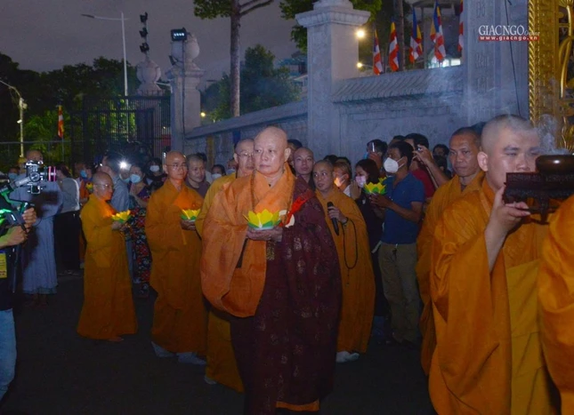 Hòa thượng Trưởng ban Trị sự cùng chư tôn đức từ từ di chuyển đến thắp sáng, phóng liên đăng trên hồ thủy phủ trước Việt Nam Quốc Tự