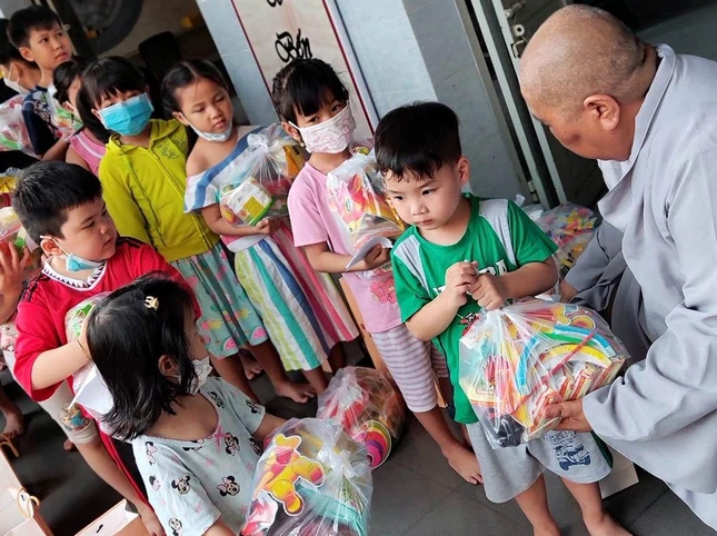 Ni sư Thích nữ Lệ Thuận, trụ trì chùa Kim Sơn trao quà cho trẻ
