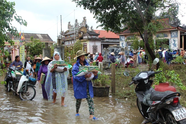 Bà con vùng ngập lũ nhận quà