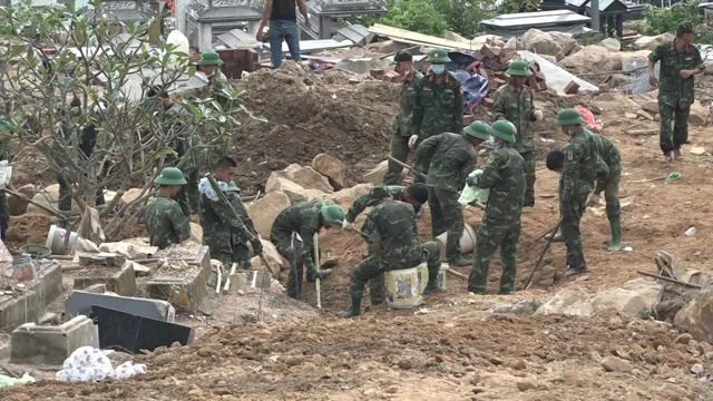 Các chiến sĩ tìm kiếm những phần mộ bị mưa lũ vùi lấp Các chiến sĩ tìm kiếm những phần mộ bị mưa lũ vùi lấp