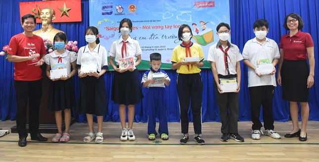 Ông Phạm Hữu Chương, Phó Tổng biên tập Tạp chí Kinh tế Sài Gòn và bà Đỗ Thị Khanh, Phó giám đốc Ngân hàng Agribank - Chi nhánh Chợ Lớn trao học bổng cho học sinh - Ảnh: Hồng Ngân