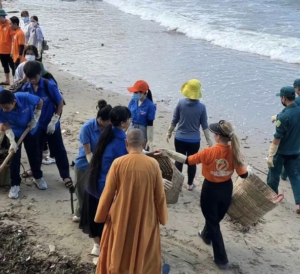 Phật tử, người dân thu gom rác thải và vệ sinh bãi biển