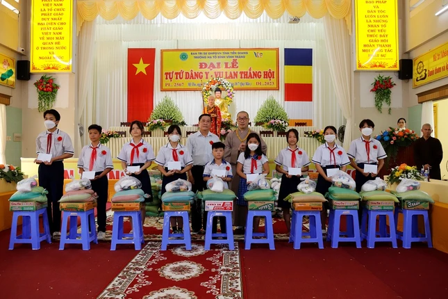 Thượng tọa Thích Quảng Lộc, Trưởng ban Trị sự GHPGVN tỉnh Tiền Giang và Phó Chủ tịch Hội Khuyến học tỉnh Nguyễn Văn Vững trao quà cho các em học sinh