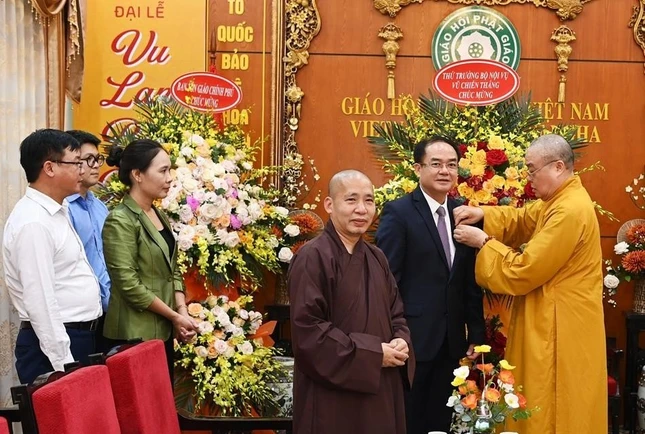 Hòa thượng Thích Thanh Nhiễu cài huy hiệu hoa sen lưu niệm đến ông Vũ Chiến Thắng Hòa thượng Thích Thanh Nhiễu cài huy hiệu hoa sen lưu niệm đến ông Vũ Chiến Thắng