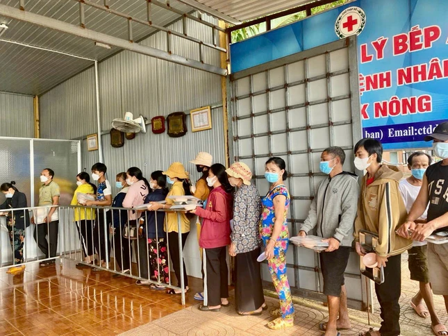 Người nghèo nhận suất cơm chay của tịnh xá Ngọc Đạt tại Bệnh viện Đắk Nông - Ảnh: N.Đ