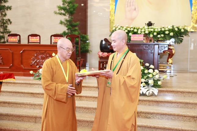 Thượng tọa Thích Nhật Hỷ, Phó Trưởng ban Kiến đàn trao đề thi đến Thượng tọa Thích Minh Cần, đại diện Ban Giám thị nhận đề thi - Ảnh: Thịnh Lã