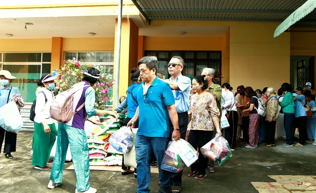 Hỗ trợ người mù nghèo đến nhận quà của đoàn từ thiện - Ảnh: CTV