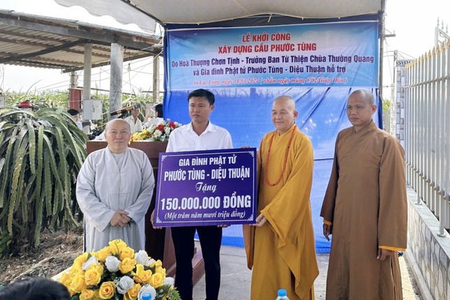 Hòa thượng Thích Minh Thiện đại diện gia đình nhà tài trợ trao tiền tượng trưng ủng hộ xây cầu