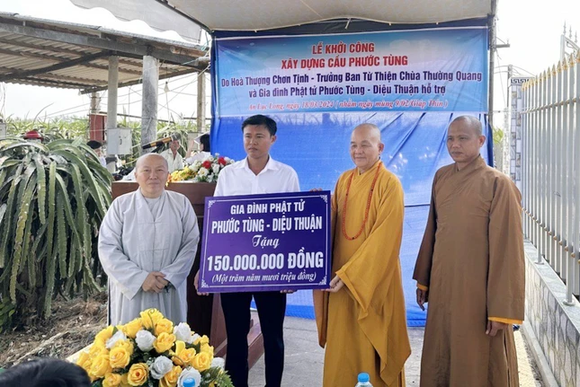 Hòa thượng Thích Minh Thiện đại diện gia đình nhà tài trợ trao tiền tượng trưng ủng hộ xây cầu