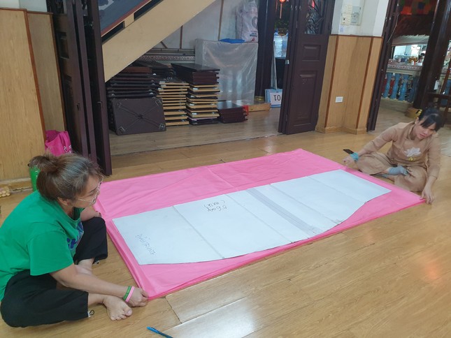 Nhiều ngày qua, chư Ni, Phật tử, tình nguyện viện tất bật cắt vải, gia cố cho những cánh sen hồng