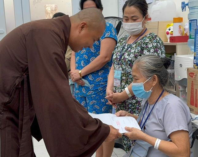 Đại đức Thích Minh Phú đóng tiền viện phí cho bệnh nhân khó khăn - Ảnh: TN