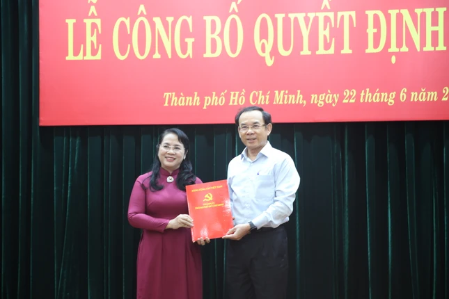 Bí thư Thành ủy TP.HCM Nguyễn Văn Nên trao quyết định đến bà Trần Kim Yến - Ảnh: Long Hồ