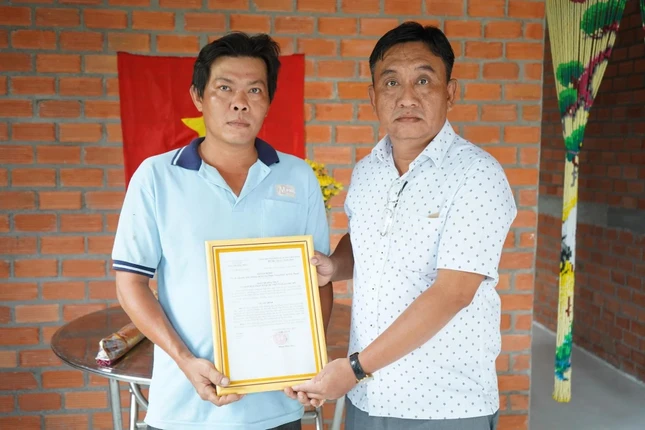 Ông Phan Văn Thường, Phó Bí thư Thường trực Đảng ủy xã Phú Mỹ trao quyết định tặng căn nhà đến anh Phạm Trung Hiếu