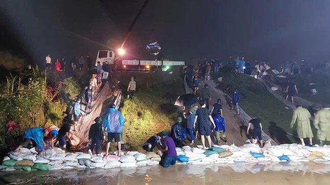 Bà con đang gia cố bờ đê - Ảnh: T.N