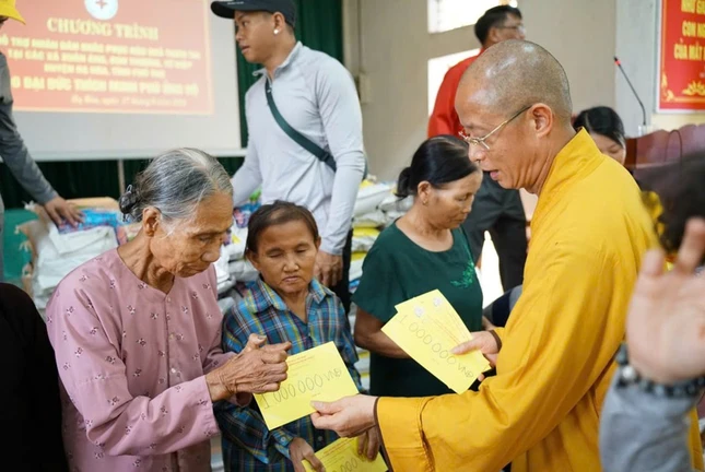 Thượng tọa Thích Minh Nghiêm trao quà đến những gia đình khó khăn do bão lũ - Ảnh: T.N