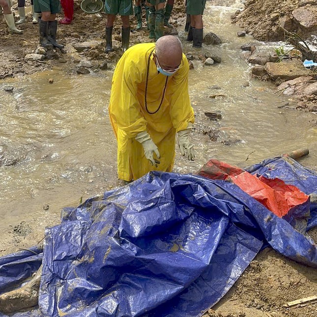 Thượng tọa Thích Vĩnh Phúc hỗ trợ gia đình rửa sạch thi thể vừa tìm kiếm