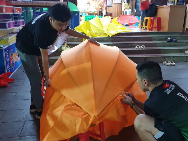 Phật tử căn chỉnh từng cánh hoa sen chuẩn bị tôn trí trên kênh Nhiêu Lộc