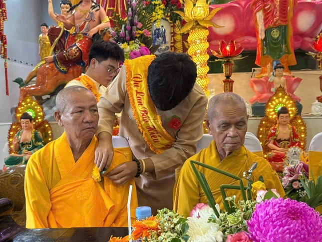 Các em thanh thiếu niên Phật tử cài hoa hồng lên huỳnh y của chư tôn đức